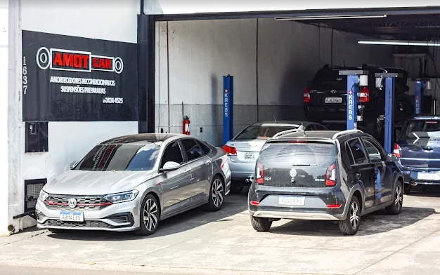 Fachada real da AMOTCAR em Piracicaba, com carros na entrada e nos elevadores.